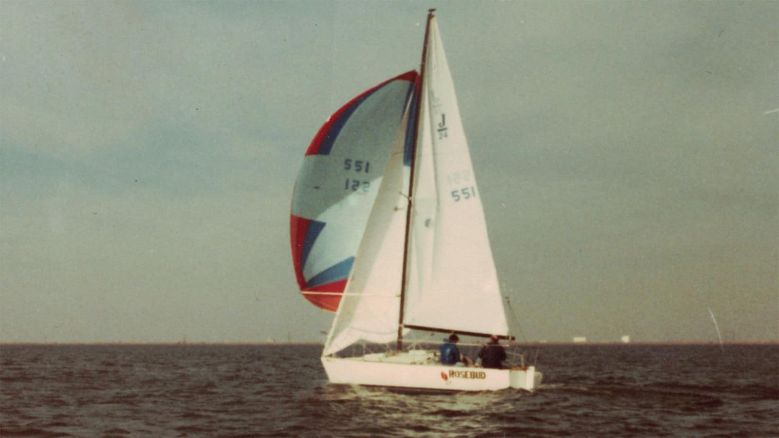 Photo of Reford Bond at the helm of his sailboat, Rosebud